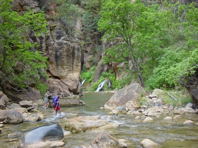 John and Marnie hiking through the Virgin River in The Narrows - Zion National Park, Utah
